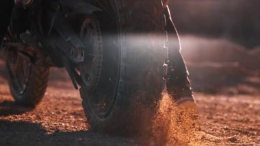 Yarışın başında motorsikletin direksiyonundan uçan kayaların ve tozun süper yavaş çekimi.