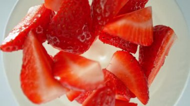 Yoğurt kremine dökülen çileklerin süper yavaş çekimleri. Hareketli ve dönüşlü yüksek hızlı sinema kamerası ile çekildi, 1000fps.