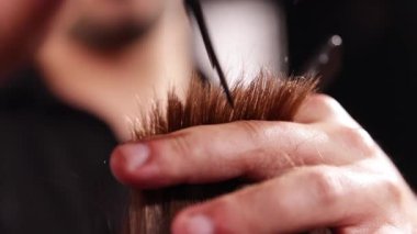 Berber dükkanındaki sakallı genç adam. Berber saç kesimini hazırlıyor. Karanlık Atmosfer, Kara Arkaplan. Berber ve Müşteri kavramı.