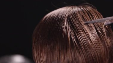 Berber dükkanındaki sakallı genç adam. Berber saç kesimini hazırlıyor. Karanlık Atmosfer, Kara Arkaplan. Berber ve Müşteri kavramı.