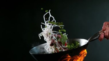 Uçan Asya tavası malzemelerinin süper yavaş çekimi. Yüksek hızlı sinema kamerası, 1000 fps.