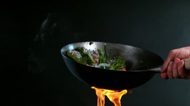 Uçan Asya tavası malzemelerinin süper yavaş çekimi. Yüksek hızlı sinema kamerası, 1000 fps.