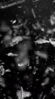 Camdan giren silah sesi çok yavaş, siyah arka plana çarpıyor, dikey yönelimli. Yüksek hızlı sinema kamerası, 1000 fps. .