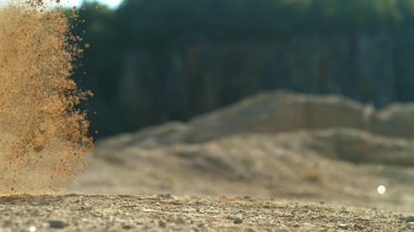 Yarışın başında motorsikletin direksiyonunda uçan kayaların ve tozun süper yavaş çekimi.