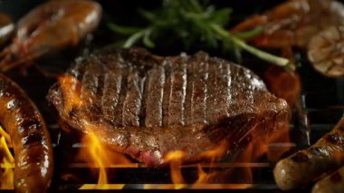 Slow Motion of Beef Steak on a Grill with Roaring Flames , Camera Move . 1000 FPS 'te Yüksek Hız Sineması Kamerası' nda çekildi. .