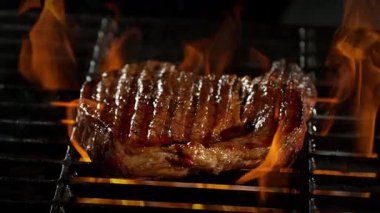 Slow Motion of Beef Steak on a Grill with Roaring Flames , Camera Move . 1000 FPS 'te Yüksek Hız Sineması Kamerası' nda çekildi. .