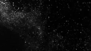 Siyah zemin üzerinde izole edilmiş küçük parçacıklar uçuşuyor. Yüksek hızlı kamera, 1000 fps.
