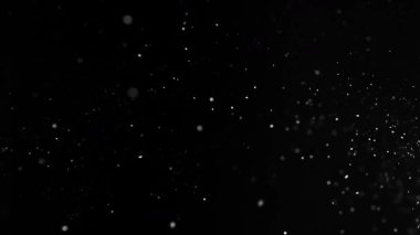 Siyah zemin üzerinde izole edilmiş küçük parçacıklar uçuşuyor. Yüksek hızlı kamera, 1000 fps.