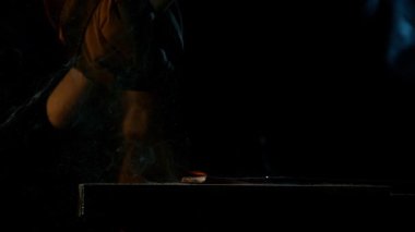 Demirciye yakın plan örsün üzerinde kızgın demirden uçan kıvılcımlar dövüyor. Süper yavaş çekim, 1000 fps hızla yüksek hızlı sinema kamerasıyla çekildi.