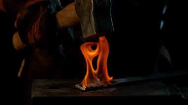 Demirciye yakın plan örsün üzerinde kızgın demirden uçan kıvılcımlar dövüyor. Süper yavaş çekim, 1000 fps hızla yüksek hızlı sinema kamerasıyla çekildi.