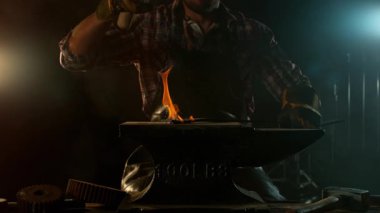 Demirciye yakın plan örsün üzerinde kızgın demirden uçan kıvılcımlar dövüyor. Süper yavaş çekim, 1000 fps hızla yüksek hızlı sinema kamerasıyla çekildi.