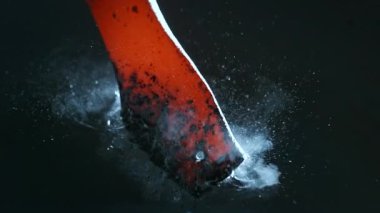 Demirci kızgın, dövülmüş metal parçayı suya koyar. Süper yavaş çekim, 1000 fps hızla yüksek hızlı sinematik kamerayla çekildi.