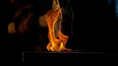 Demirciye yakın plan örsün üzerinde kızgın demirden uçan kıvılcımlar dövüyor. Süper yavaş çekim, 1000 fps hızla yüksek hızlı sinema kamerasıyla çekildi.