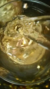 Kameranın hareketinin çok yavaş bir şekilde şampanya kadehine dönüşmesi. Su altı makro mercekli eşsiz bir açı. Kutlama ve başarı kavramı. Yüksek hızlı sinema kamerası, 1000 fps.