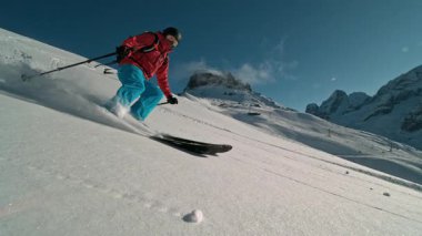 Manzaralı Dolomitler dağlarında kayakçı taze toz karda kayıyor. 1000 fp 'de süper yavaş çekim..