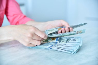 Businesswoman working in office and holding usd  banknote in hand. Success, business and financial idea concept. Close up