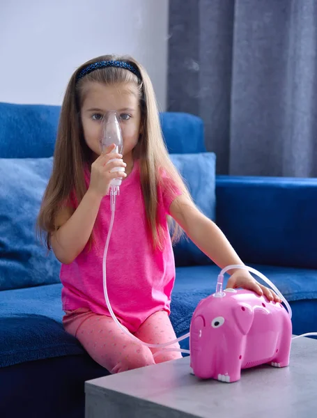 Маленькая Девочка Ингалятором Розовой Копилкой Диване Дома Здравоохранение Медицинская Концепция — стоковое фото