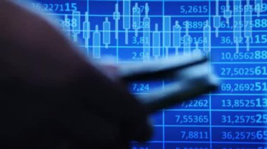 Mavi borsa tablosuna odaklan. El ele tutuşup paraları saymak. Finans ve yatırım kavramı