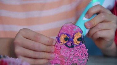 Çocuk renkli bir yapı yaratmak için 3 boyutlu kalem kullanıyor. Sanat konseptinde yaratıcılık ve yenilik. Kapat.
