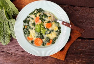 Lahanalı sağlıklı sebze çorbası. Koyu bir ahşap arka planda, masanın üstünde. .