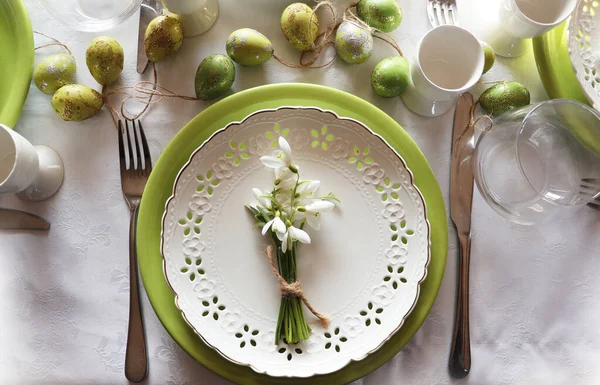Stylish Easter table setting. Natural egg , snowdrops , modern plate, cutlery. Modern Easter table decoration .