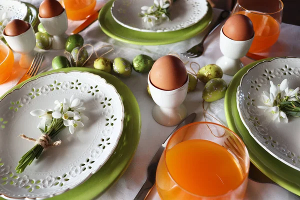 Stylish Easter table setting. Natural egg , snowdrops , modern plate, cutlery. Modern Easter table decoration .