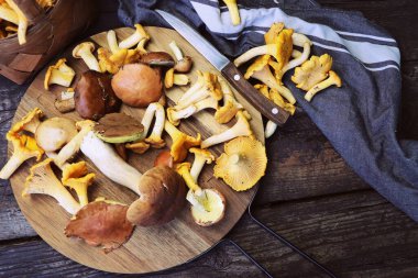 Orman karışımı kesme tahtası üzerinde eski ahşap masa üzerinde mantar. .