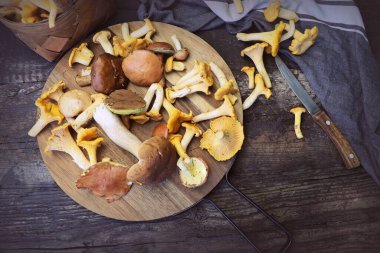 Orman karışımı kesme tahtası üzerinde eski ahşap masa üzerinde mantar. .