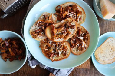 Chanterelle sandwiches with cheese. Open faced sandwich with creamy , seasonings and pepper and herbs on an old wooden background. Mock up. Top view.