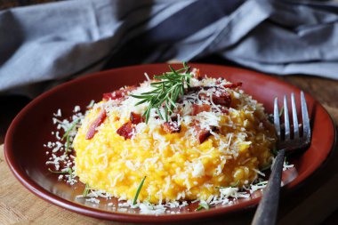 Koyu ahşap bir masada balkabağı ve pastırmalı risotto. Üst görünüm .