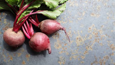 Mavi arka planda yaprakları olan taze pancar kökü. Sağlıklı yiyecekler. Üst Manzara. Metnin için boş yer.