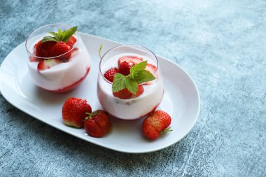 Mavi arka planda krem şantili kırmızı çilek.