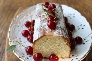 Eski ahşap arka planda kirazlı sünger kek. Yaz meyveli bisküvi.
