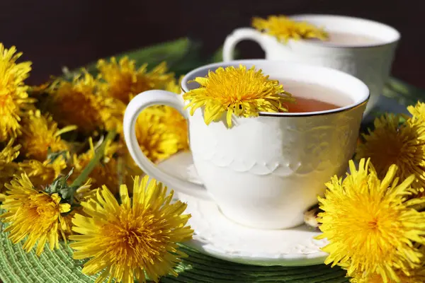  Fincanın içinde taze sarı bir çiçek olan karahindiba çayı. Vitamin içeceği. Sağlık için karahindiba bitkisi çayı.