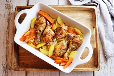 Patates ve havuçlu kızarmış tavuk budu. Tavuk budu ızgarada yakın plan çekimde ızgara. Yukarıdan yatay görünüm