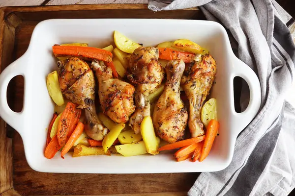 Patates ve havuçlu kızarmış tavuk budu. Tavuk budu ızgarada yakın plan çekimde ızgara. Yukarıdan yatay görünüm