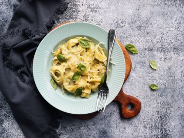 Tortellini otlar, ricotta, ıspanak ve taze fesleğenle dolu. Üst görünüm
