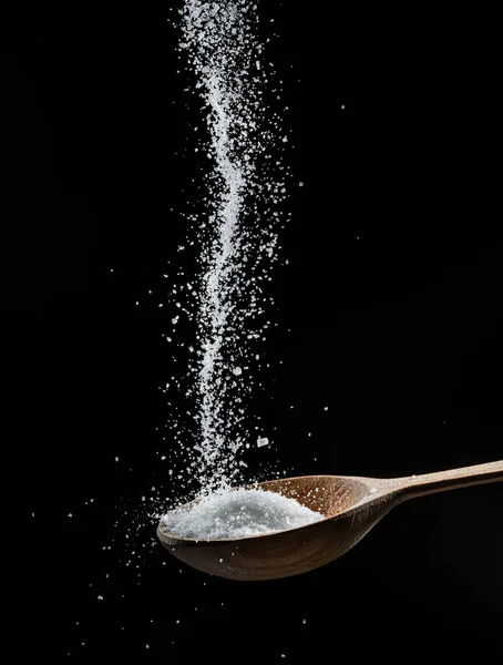 White Refined Sugar Crystals Falling Wooden Spoon Black Background — ストック写真