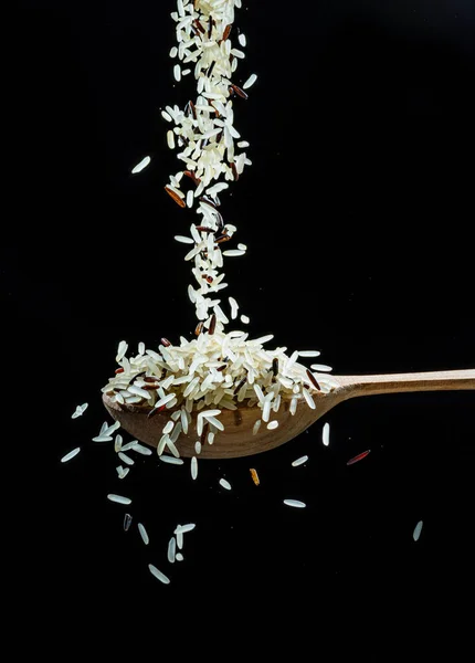 White Rice Grains Falling Spoon Black Background Popular Food Main — Stock Photo, Image