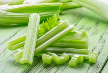 Yeşil ahşap masada bir yığın kereviz kaburgası. Sağlıklı gıda geçmişi.