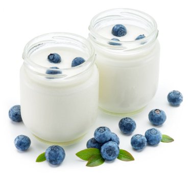 Beyaz arka planda sade yoğurt ve meyveli iki cam kap..