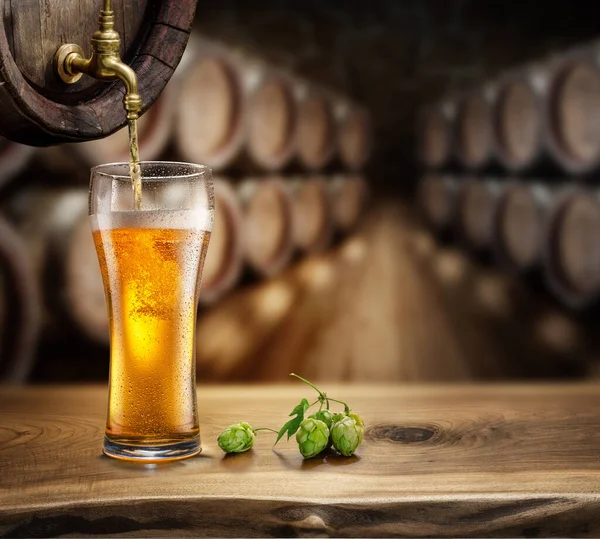 Pouring Beer Glass Wooden Barrel Blurred Brewery Cellar Background — Stock fotografie