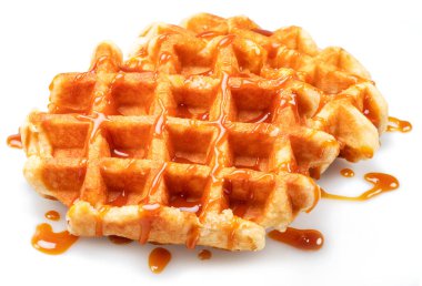 Belgian waffle with caramel topping isolated on white background.