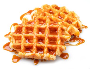 Belgian waffle with caramel topping isolated on white background.