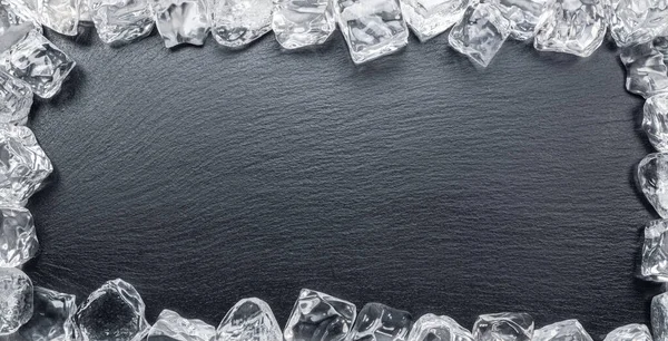 フレームとして配置された氷のキューブと天然石の黒スレートサービングプレート — ストック写真