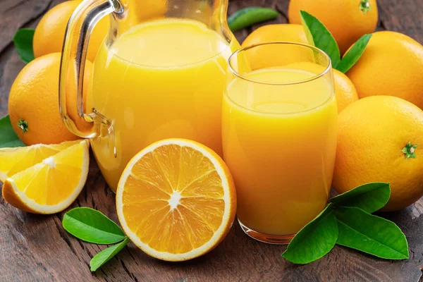濃緑色の木の背景に単離された黄色のオレンジ果実と新鮮なオレンジジュース — ストック写真