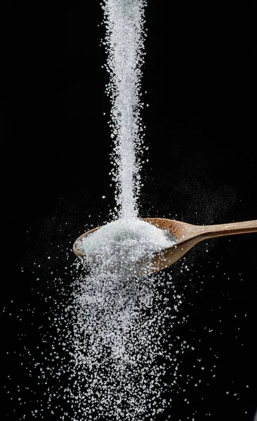 White Refined Sugar Crystals Falling Wooden Spoon Black Background — Fotografia de Stock