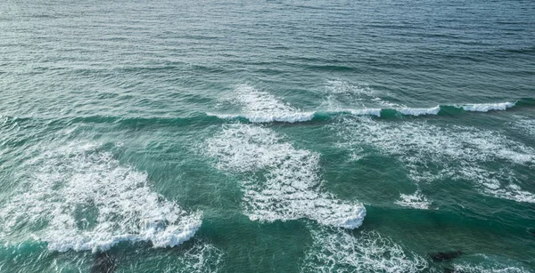 海洋泡沫波接近岩石海岸 顶部视图 — 图库照片