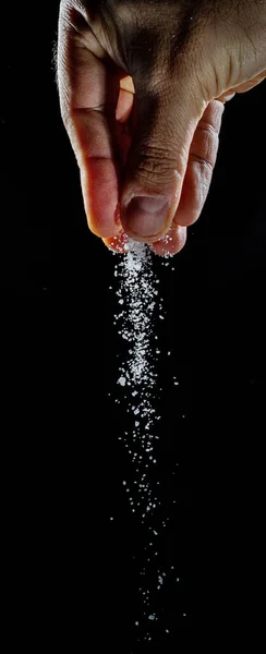Mężczyzna Ręka Posypywanie Biały Rafinowane Kryształy Cukru Czarnym Tle — Zdjęcie stockowe