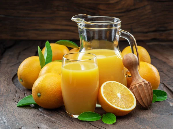 黄色的橙子和鲜橙汁 在深色的木制背景上隔离 — 图库照片